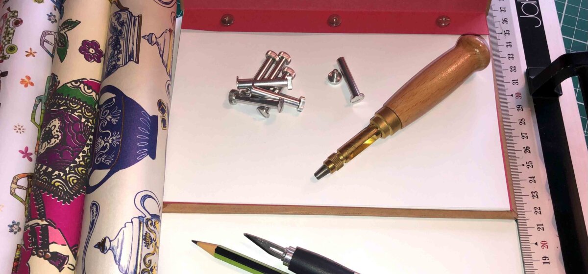Laid out materials, such as paper, pens and tools required for the technique of bookbinding.