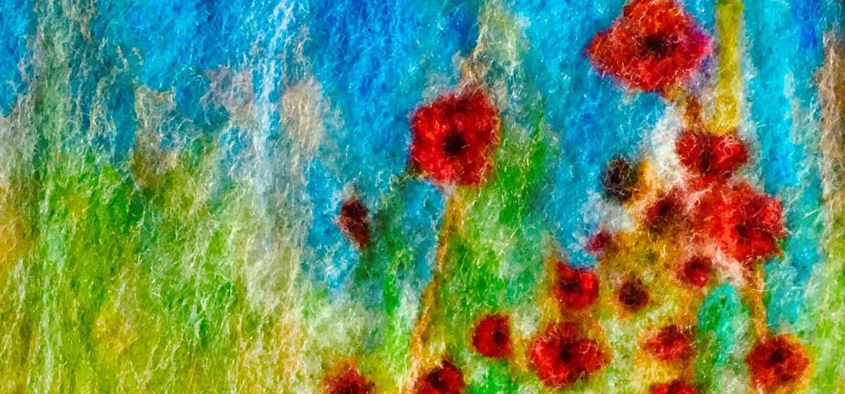 A needle felting of a field with poppies