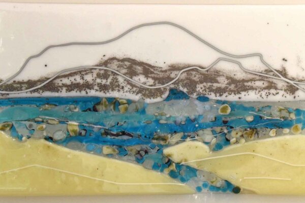 A rectangle piece of glass art with an artistic seascape fused into the glass