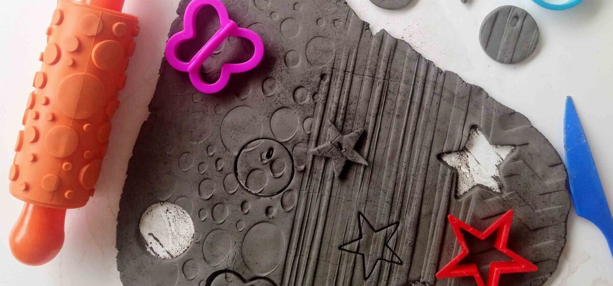 Black clay is moulded into star, circular and butterfly shapes.