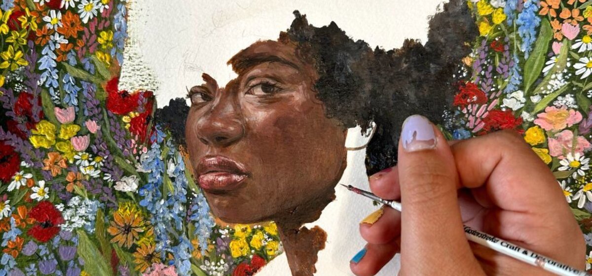 An image for Figurative portraiture exploring the female form at The Base, pictured is someone's hand painting a beautiful floral piece around a woman's portrait
