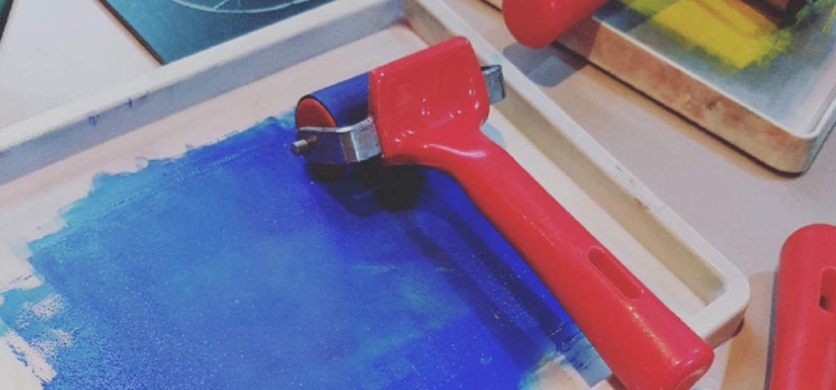 An image of Blue paint with a red roller