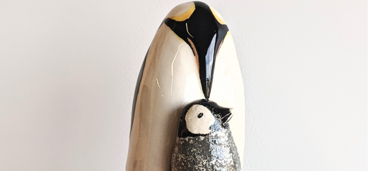 Two clay penguins against a white background