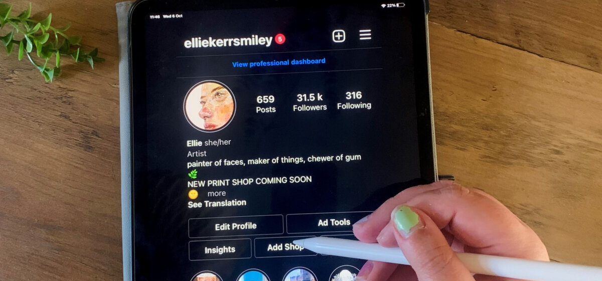 Ipad screen open on an instagram page with hanf holding i-pen above it.