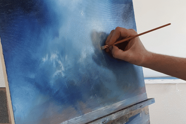 Painting an oil landscape. blue tones with white and pale tones.