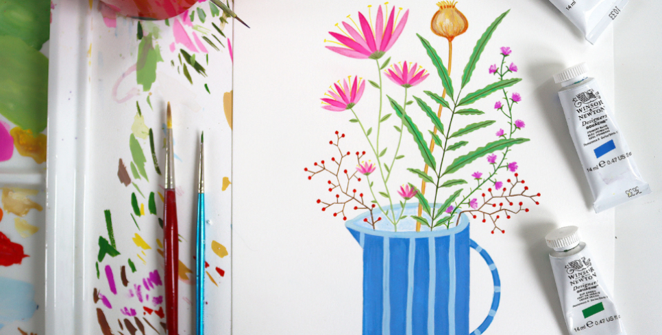 An image of a painted jug of flowers. On the left of the painting there are two paintbrushes with tested paint and on the right there are tubes of gouche paint in green and blue.