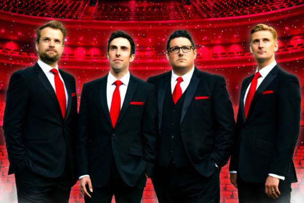 A photo of the four Opera Boys with a theatre tinted red behind them. They are all also wearing red ties.