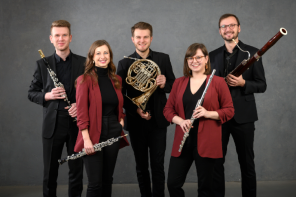 Alinde Quintet stood on grey background with their instruments