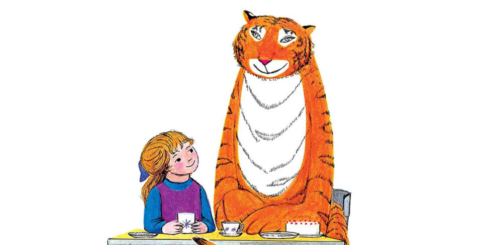 A little girl sits next to a large tiger at a dinner table