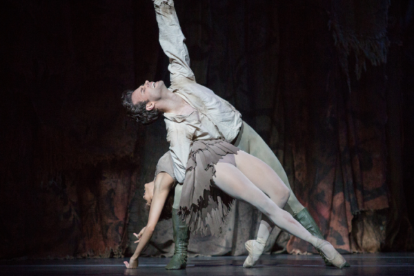 Two ballet dancers elegantly pose on stage