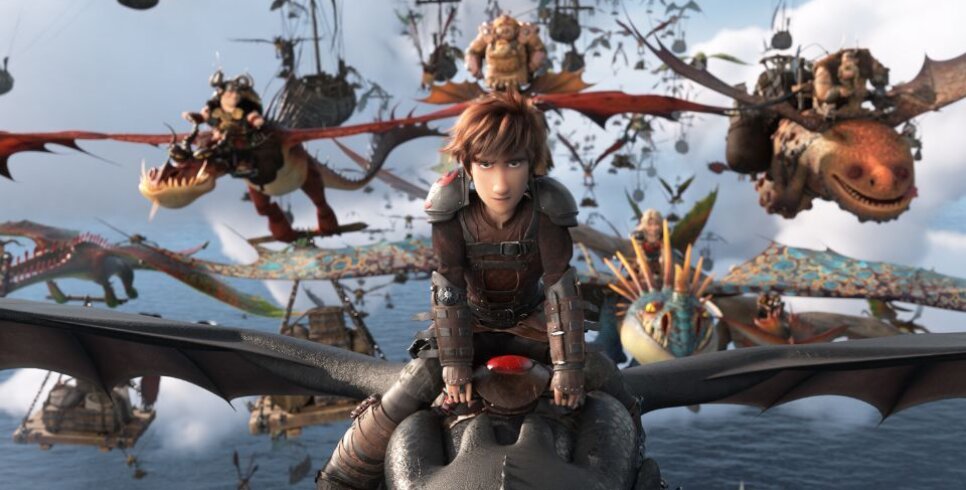 A still of Hiccup riding Toothless and leading a group of other Vikings on their dragons.