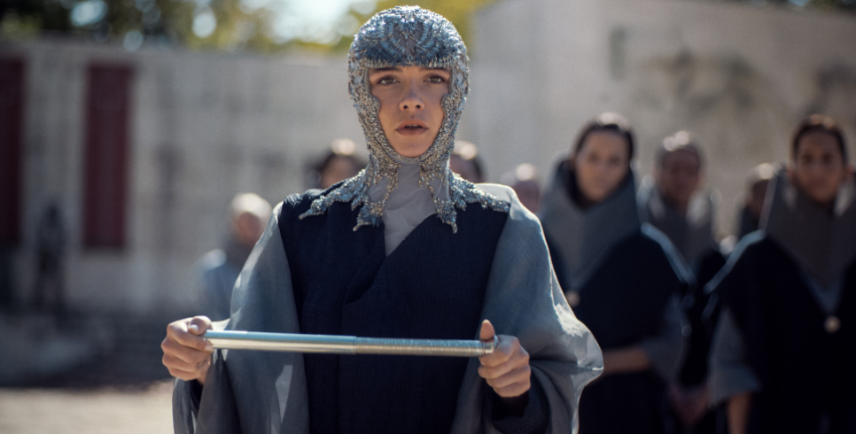 Florence Pugh walks towards the camera wearing full chainmail