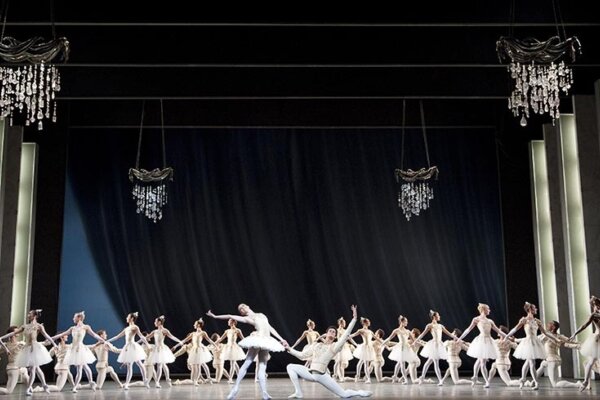 stage filled with ballerinas on a black background