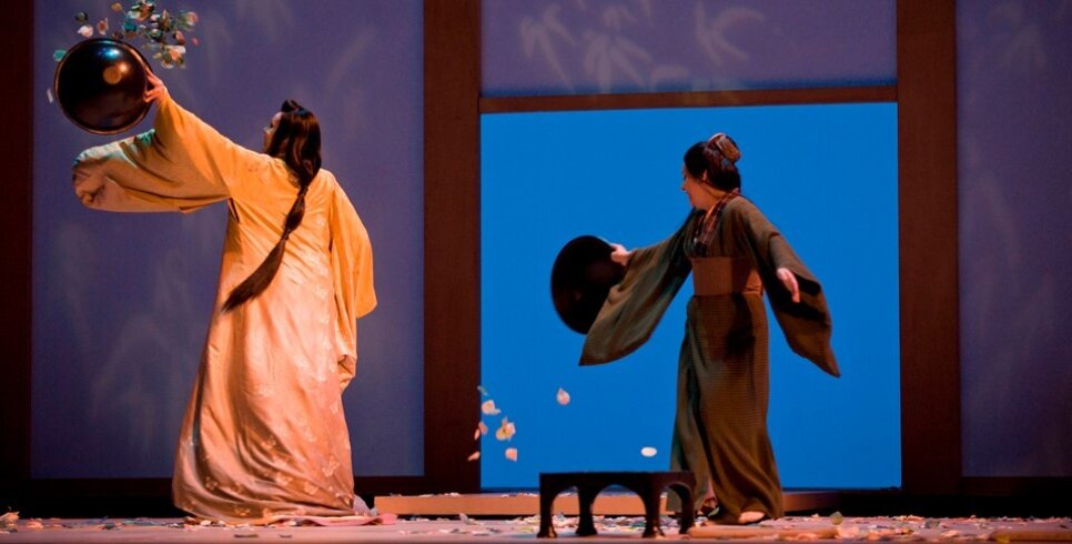 Two women dressed as geisha's stood on a stage