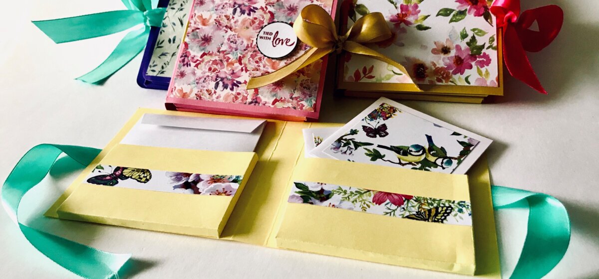 Packs of note cards decorated with floral designs and tied with ribbon.