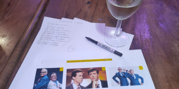 Quiz sheets with a pen and a glass of wine
