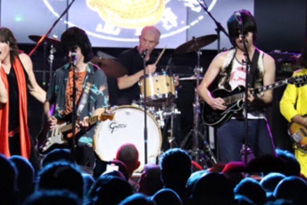 An image from The Counterfeit Stones show coming to the Corn Exchange Newbury. Five band members all play to a large crowd on stage backed by the classic Counterfeit Stones logo of the tongue sticking out.
