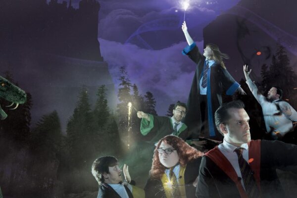 An image from Spontaneous Potter showing at Corn Exchange Newbury, a group of wizards and witches all huddle together in the fog pointing their wands into the air and casting spells
