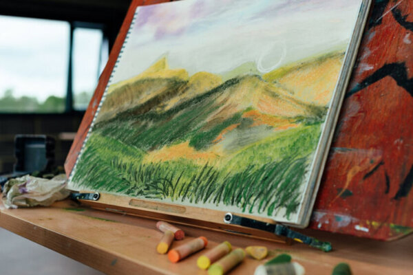 pastel landscape drawing with greens and yellows throughout in The Base Lookout Studio