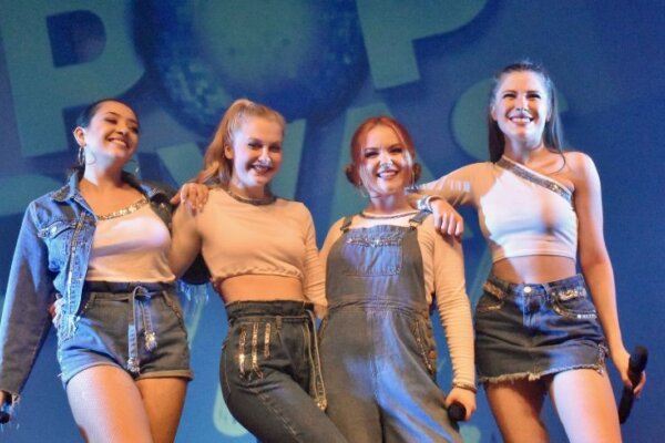 Four girls on stage wearing denim
