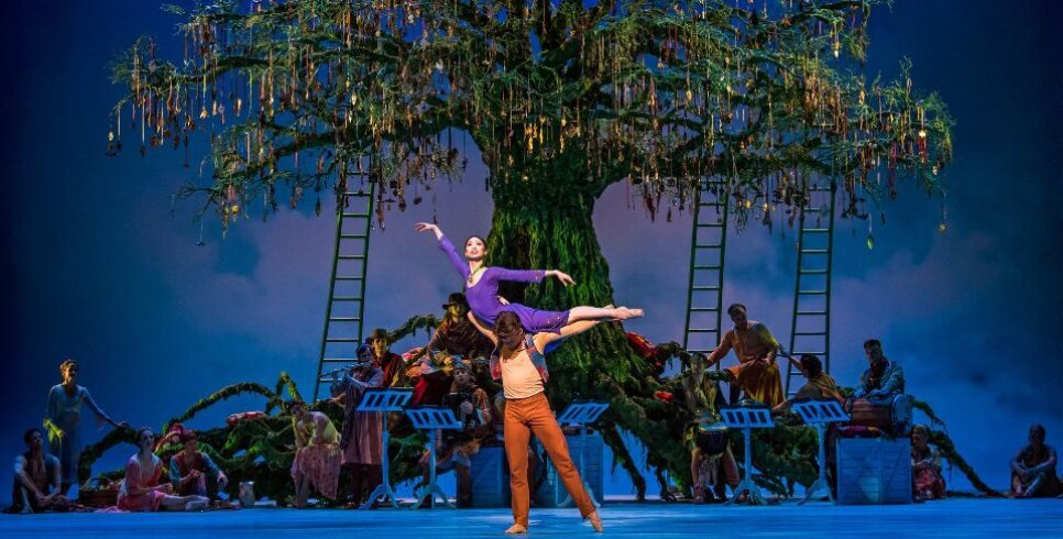 A male dancer holds a female dancer in a stunning overhead lift in front of a large tree in the centre of the stage in this live screening of The Winter's Tale at Corn Exchange Newbury