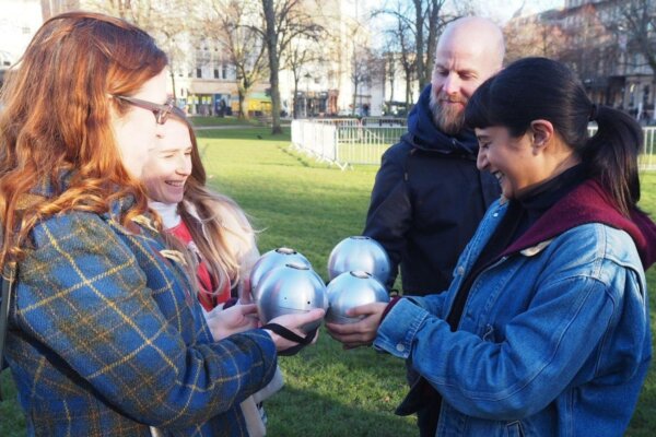 Four people stand in a circle holding sound emitting globes as part of Ray Lee's Congregation, presented by 101 Outdoor Arts in Newbury.