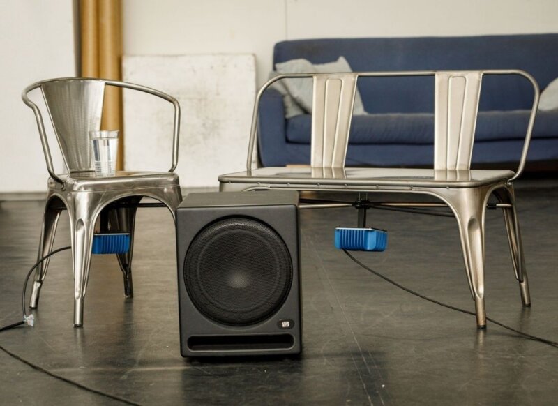 A metal chair and metal sofa with a music speaker set in a large warehouse at 101 Outdoor Arts